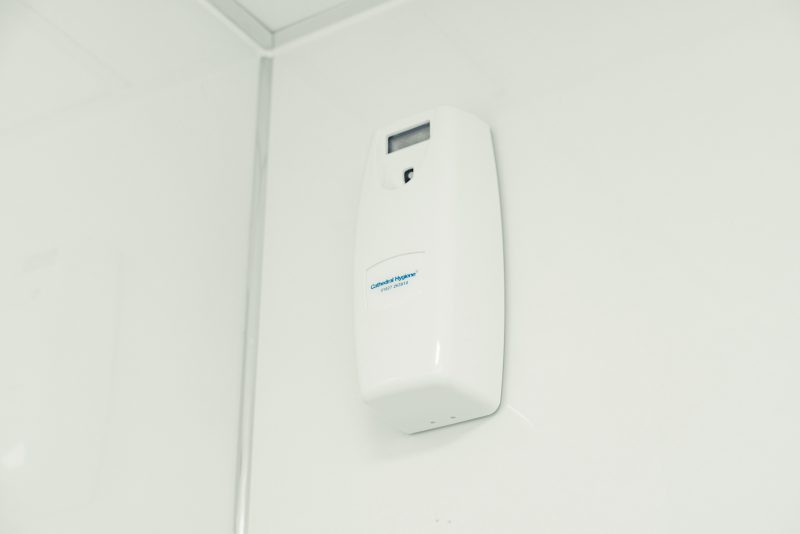 A white wall-mounted air freshener unit.